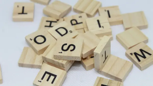 Loose wooden letter tiles scattered on a white surface